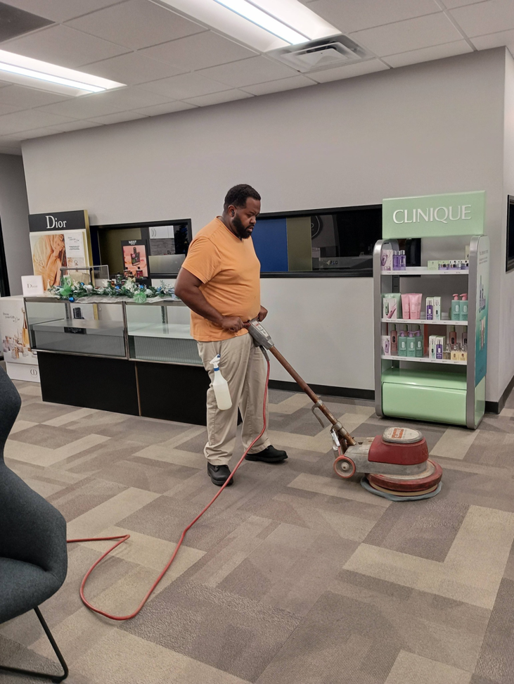 A KCclean technician cleaning commercial carpet with a floor machine in Arlington, TX