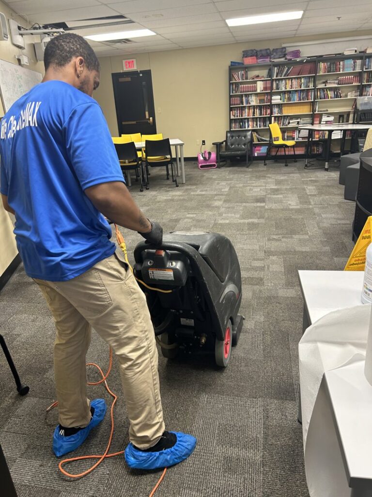 A man from 2themax Services LLC cleaning office carpet with a floor scrubber in Carmel, IN.