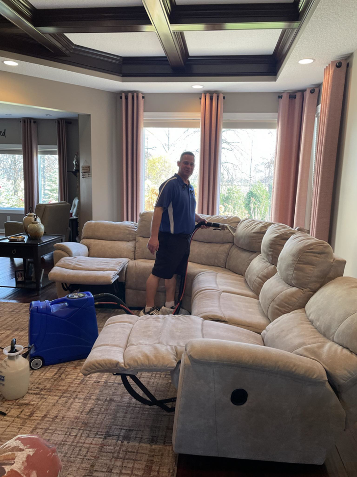 A professional from SM Cleaning Services, LLC cleaning a rug with specialized equipment in a living room in Tampa, FL.