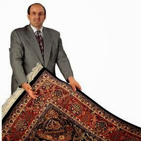 A man proudly displaying a large, intricately designed oriental rug from Zakian Rug Cleaning in Philadelphia, PA