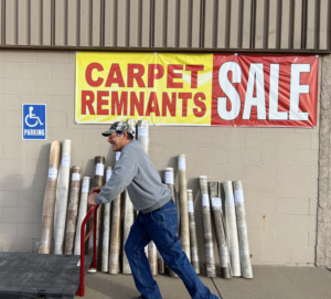 A man moving rolls of carpet remnants during a sale at Mozak's Floors & More in Yankton, SD