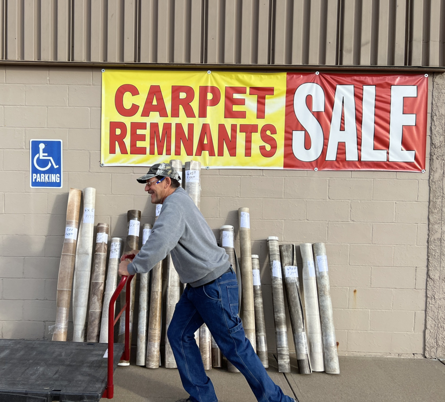 A man moving rolls of carpet remnants during a sale at Mozak's Floors & More in Yankton, SD