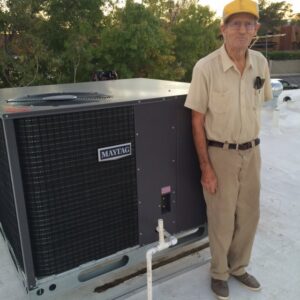 A man standing next to a large rooftop HVAC unit installation by AC Plus Heating & Air Conditioning Service in Las Vegas, NV.