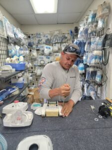 A man repairing an automatic pool cleaner device at Northwest Pool and Spa Dunlap in Phoenix, AZ.