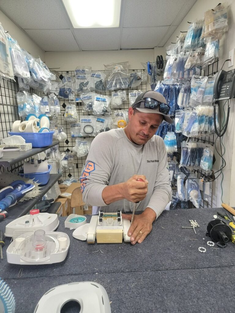 A man repairing an automatic pool cleaner device at Northwest Pool and Spa Dunlap in Phoenix, AZ.