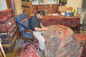 A skilled craftsman repairing an oriental rug at Bijar Oriental Rugs, a carpet contractor in Atlanta, GA.