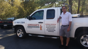 A professional standing next to a Lenegar's Pest & Moisture Services truck in Virginia Beach, VA, ready for pest control.