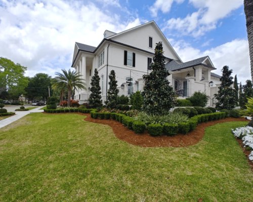 A large house with a beautifully manicured lawn and neatly trimmed hedges by Fresh Cuts Nola Lawn Service in New Orleans, LA.