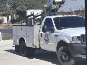 A Mario Electric service truck with a boom lift, ready for electrical work in San Antonio, TX.