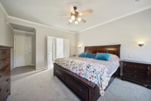 A spacious master bedroom showcasing a new gray carpet installation by B A Carpet and Flooring in Broken Arrow, OK.
