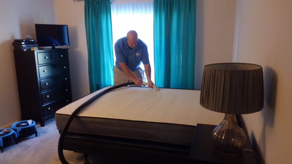 A professional cleaning a mattress with specialized equipment at Customer First Carpet Cleaning in Appleton, WI