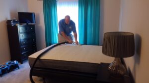 A professional cleaning a mattress with specialized equipment at Customer First Carpet Cleaning in Appleton, WI