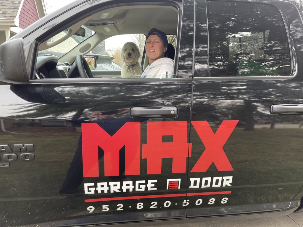 A Max Garage Door service truck with a technician and dog inside, ready for a job in Minneapolis, MN.