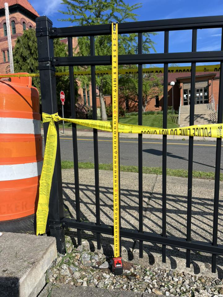 Measuring the height of a black ornamental fence installed by Oxford Fence Company in Oxford, CT.