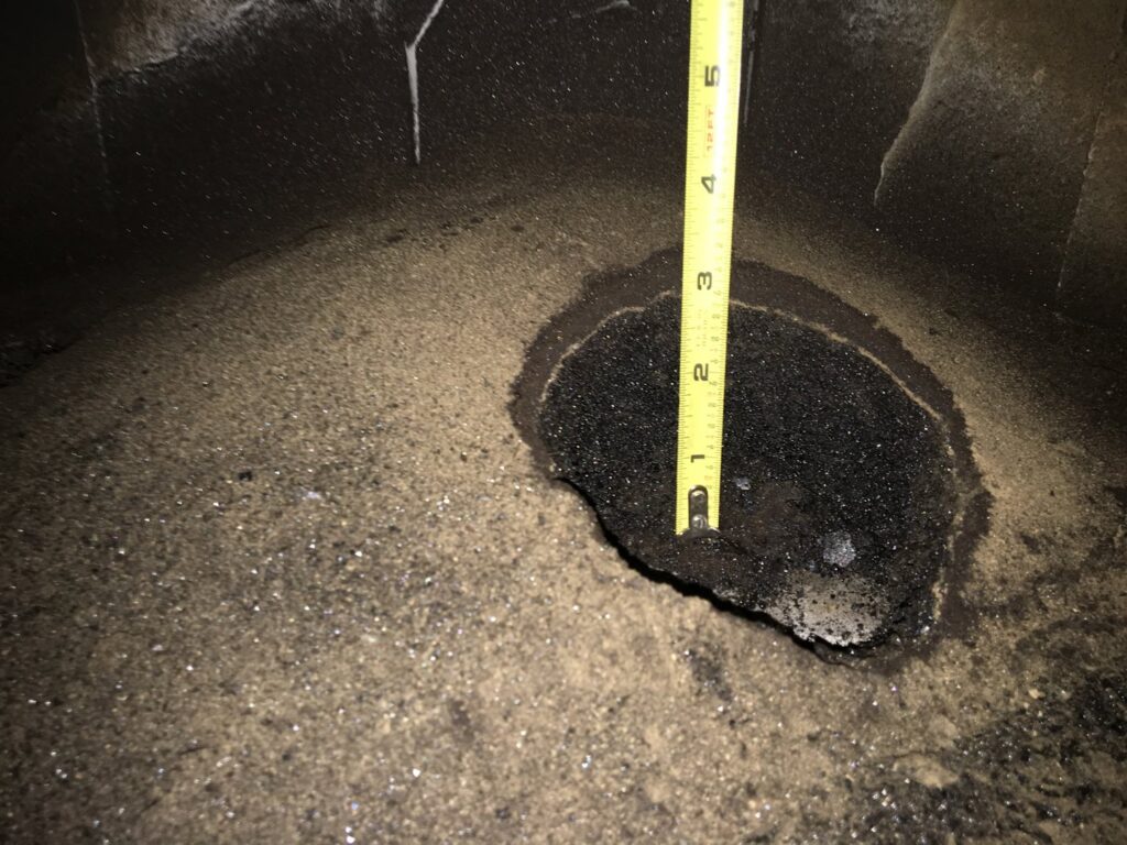 A ruler measuring creosote buildup inside a chimney flue during an inspection by Northwest Chimney in Bremerton, WA.