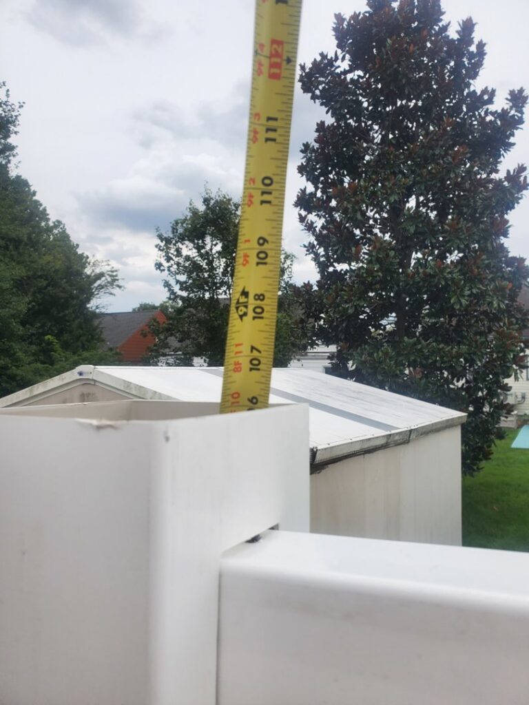 A close-up of a measuring tape on a white vinyl fence post, highlighting precision work by Fox Fence Enterprises Inc in Clifton, NJ.