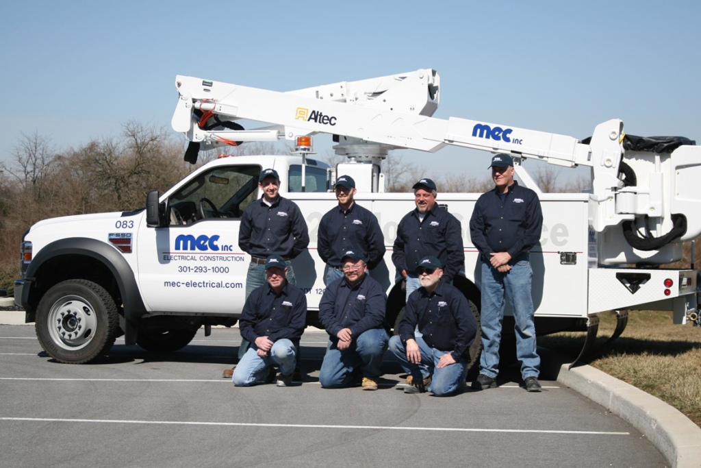 The MEC, Inc. electrician team posing with their bucket truck for electrical construction in Hagerstown, MD