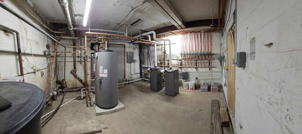 A comprehensive mechanical room setup with multiple boilers and extensive piping installed by Perfect Temp LLC in Bozeman, MT.
