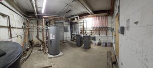 A comprehensive mechanical room setup with multiple boilers and extensive piping installed by Perfect Temp LLC in Bozeman, MT.