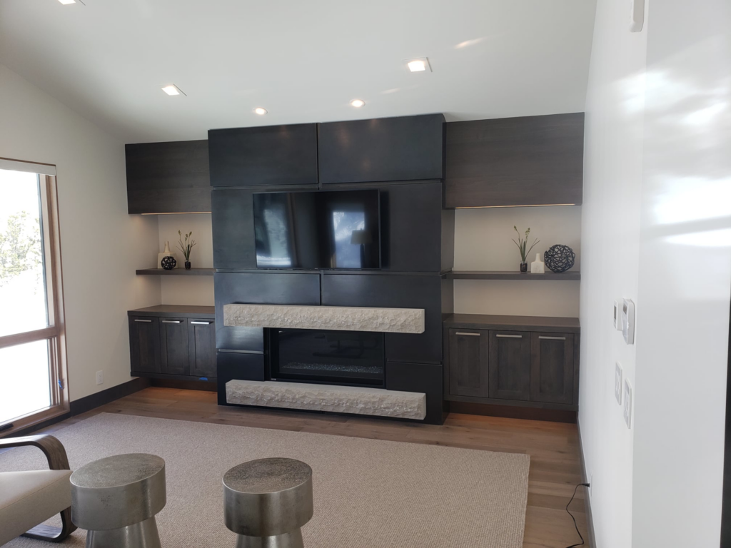 Custom media center with fireplace, mounted TV, recessed and under-shelf lighting by TBS Electric in West Jordan, UT.
