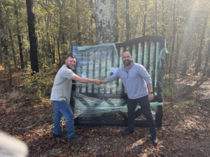 Two men shaking hands in front of a newly delivered black metal gate by All With Us LLC in Green Cove Springs, FL.