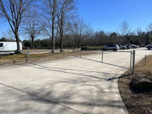 A simple metal barrier gate across a driveway with a chain link fence by Gates Contractors in Plymouth, MN.