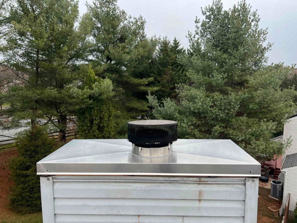 A metal chimney cap installed on a residential chimney, showcasing work by A Sweep Across the Bay in Parrish, FL.