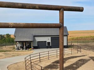 A completed metal corral system installed around a building by H&S Fencing & Supply in Linden, WI.
