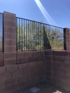 A metal fence with block pillars and integrated mesh panels, installed by Arizona Snake Fence LLC in Tucson, AZ