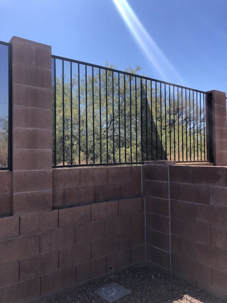 A metal fence with block pillars and integrated mesh panels, installed by Arizona Snake Fence LLC in Tucson, AZ