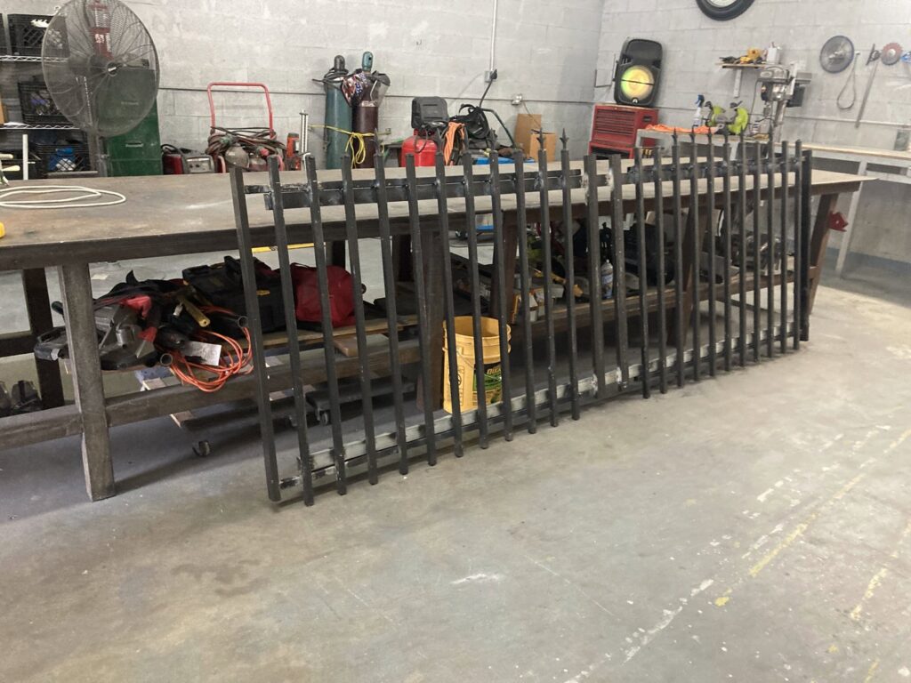 Metal fence panels being fabricated in a workshop by Allende J. Service Corp, a fencing contractor in Miami, FL.
