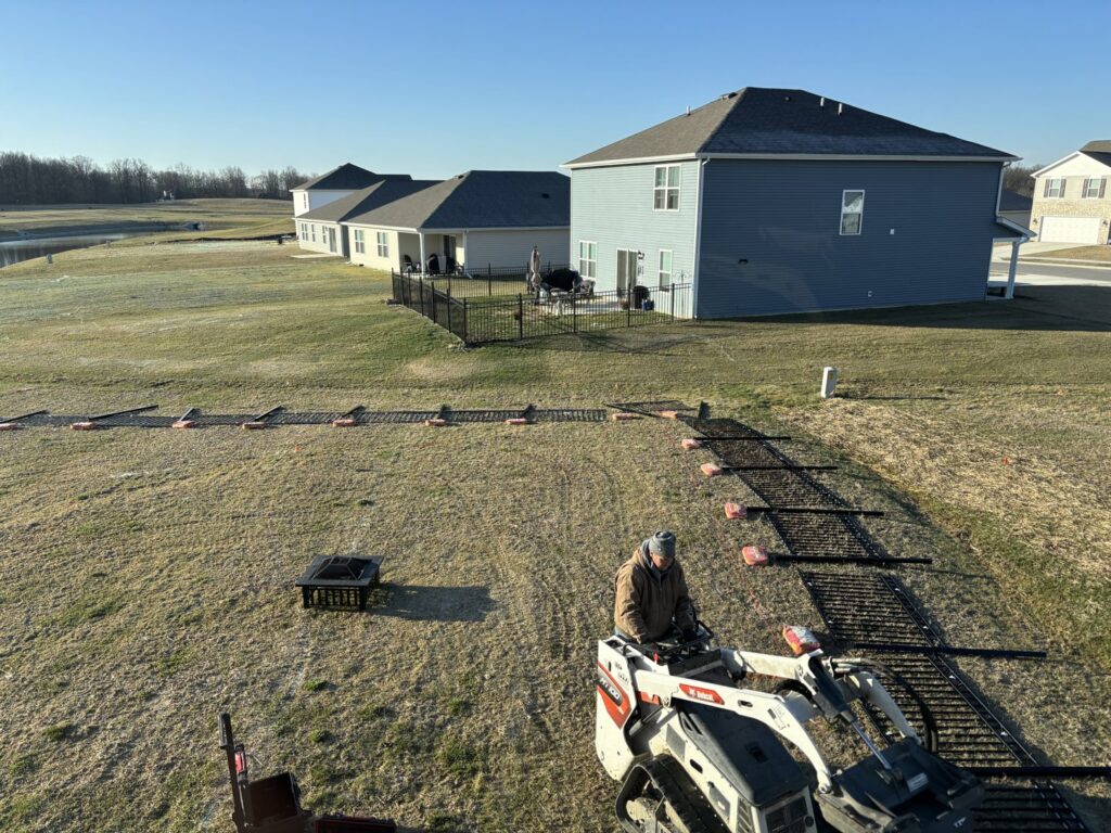 Metal fence panels laid out on the ground, ready for installation by NBBJ Fence LLC at a job site in Bluffton, IN.