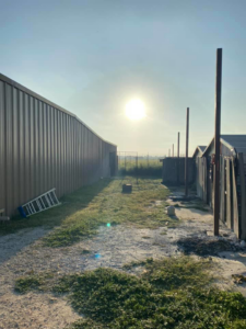 Metal fence posts being installed for an outdoor enclosure by Triple J Welding and Fabrication in San Antonio, TX.