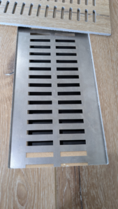 A metal floor vent being installed or serviced by BYLT Living, an HVAC contractor in Sandy, UT