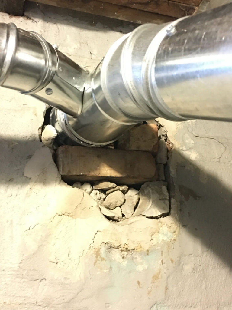 A metal flue pipe installed through a wall, part of a chimney liner installation or repair by Chimney Usa Inc in Chicago, IL.