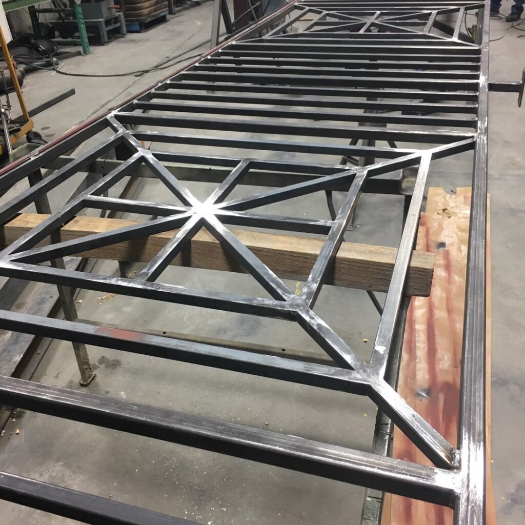 A metal gate frame being fabricated in a workshop by Roy & Son Fencing in Lee's Summit, MO.