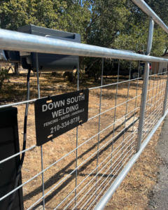 A metal gate with the Down South Welding and Fabrication business sign, showcasing fencing and gate services in Canyon Lake, TX.