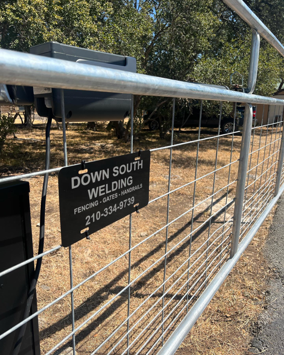 A metal gate with the Down South Welding and Fabrication business sign, showcasing fencing and gate services in Canyon Lake, TX.
