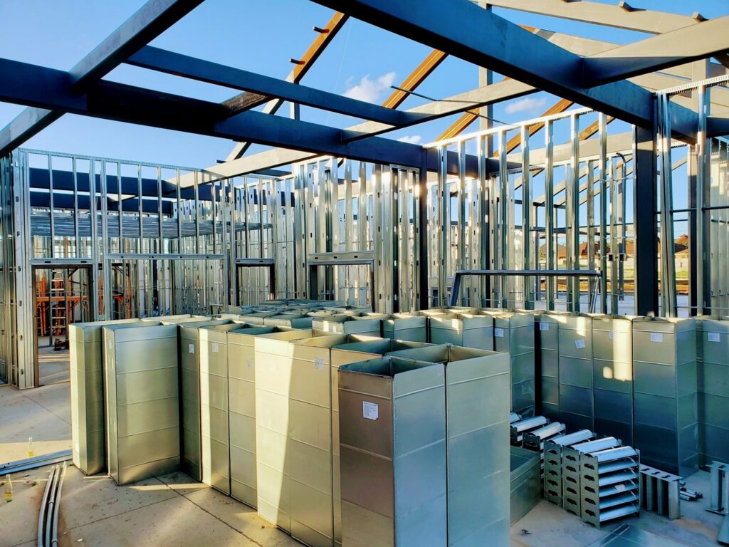 Metal HVAC ductwork components stacked inside a commercial building by Norway Air Conditioning Inc. in Laredo, TX.