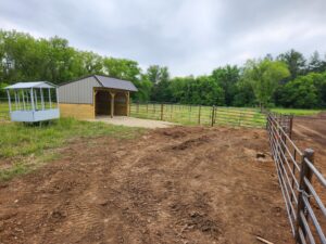 Extensive metal panel fencing installed around a large paddock area by H&S Fencing & Supply in Linden, WI.