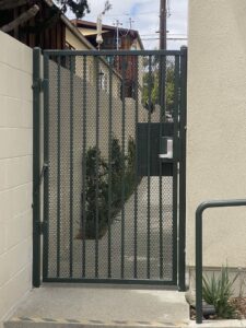 A dark metal security gate with a keypad lock installed by All Around Fence Page in Imperial Beach, CA.