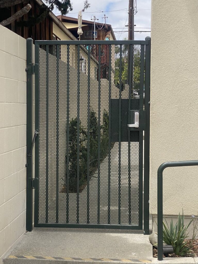A dark metal security gate with a keypad lock installed by All Around Fence Page in Imperial Beach, CA.