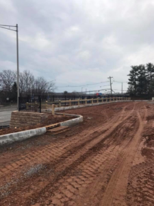 Combination of black metal and wood post-and-rail fencing installed at a construction site by Keith's Fence Co LLC in Edison, NJ.