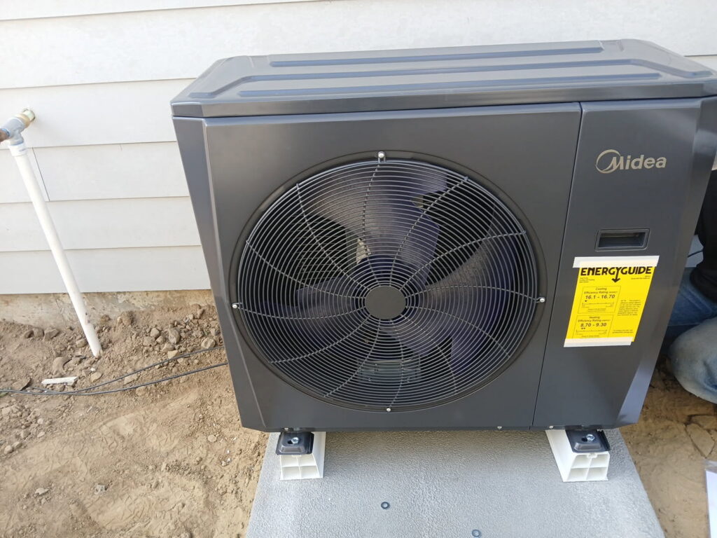 A Midea outdoor heat pump unit recently installed on a concrete pad by Semenik Hvac/r in Spokane, WA.