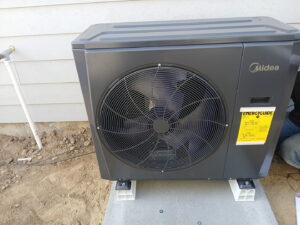 A Midea outdoor heat pump unit recently installed on a concrete pad by Semenik Hvac/r in Spokane, WA.