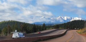 A Midtown Chimney Sweeps van driving on a highway with mountains in the background near Golden, CO.