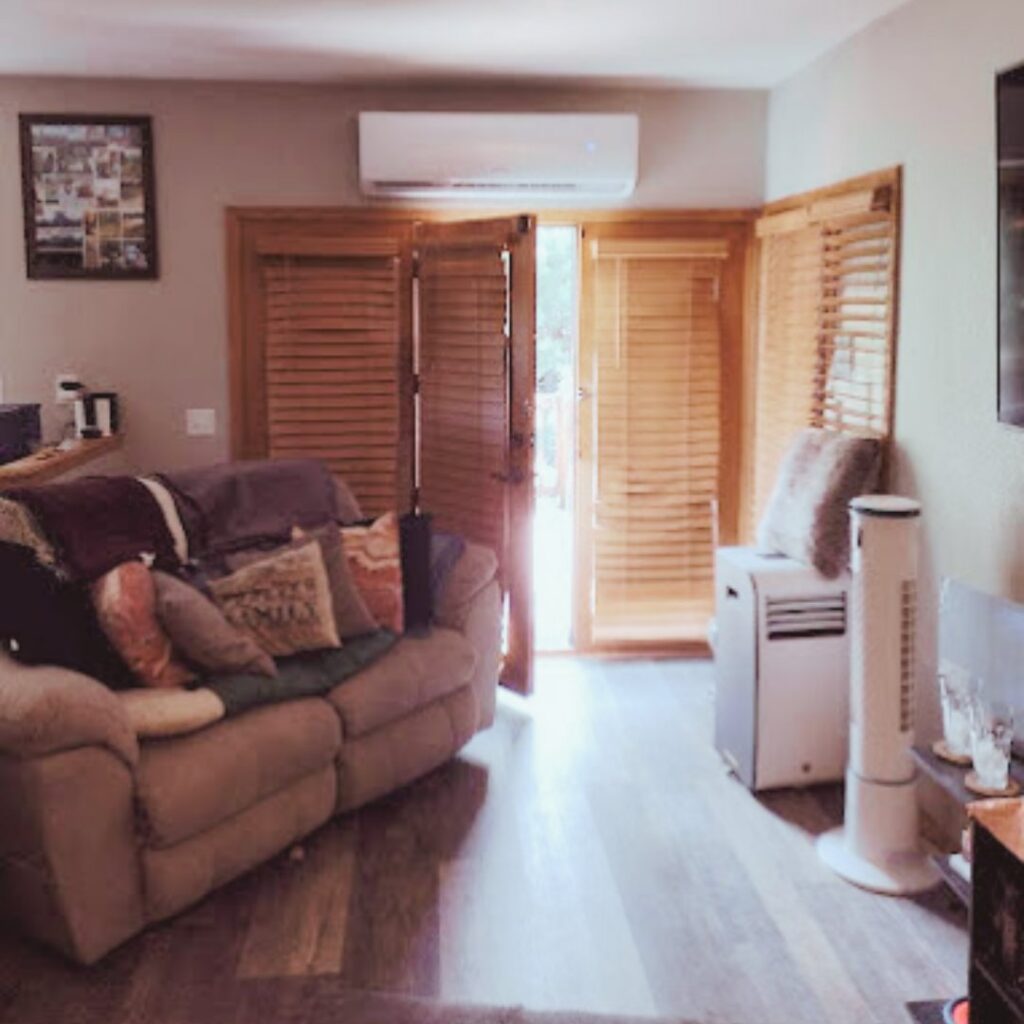 An indoor mini-split air conditioning unit installed above a doorway in a living room by Jump HVAC in Lakewood, CO.