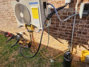A Samsung mini-split AC unit being installed or serviced with gauges and vacuum pump by OKIE Heating and Cooling in Tulsa, OK.