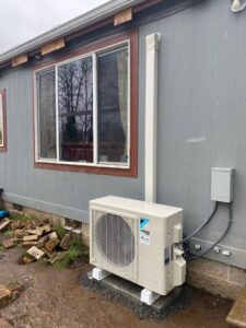 An installed Daikin mini-split AC outdoor unit next to a home by Alpine Heating in Eugene, OR.