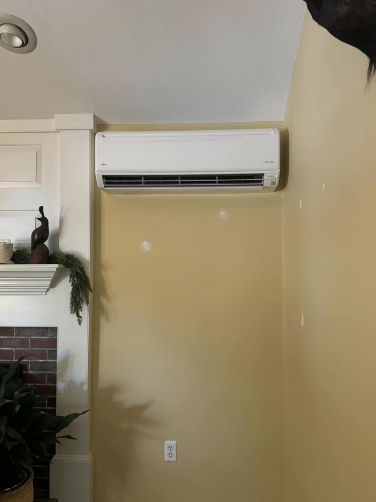 An indoor mini-split AC unit installed above a fireplace mantel by Precision Heating and Gas Service in Derry, NH